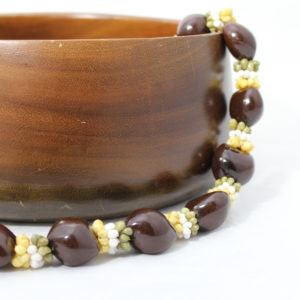 brown kukui nut lei with white and yellow shells